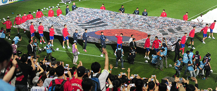 Players on the Korean national soccer team are presented to the crowd on May 29 as they carry a huge Taegeukgi, the Korean national flag. (photo: Jeon So-hyang, Ministry of Culture, Sports and Tourism)