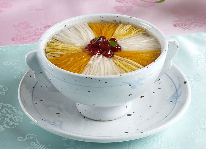 <i>Yuja hwachae</i> was a court drink consumed to prevent catching a cold. Decorated with thin slices of pear and citron, and seeds from a pomegranate in the center, this drink also looks very beautiful.