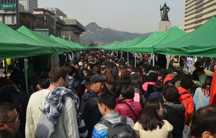 The statue of Admiral Yi Sun-shin towers over bargain-hunters in a crowded part of the Sejongno street market (photo: Jon Dunbar).