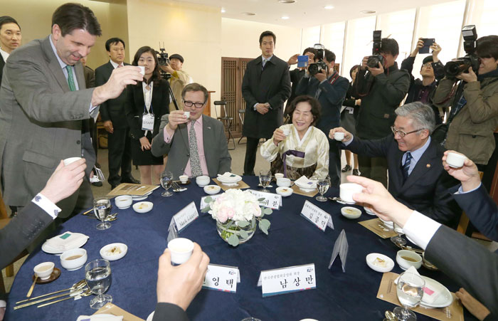 Minister of Culture, Sports and Tourism Kim Jongdeok (right) raises his glass with other attendees at the food tasting, as U.S. Ambassador to Korea Mark Lippert (left) proposes a toast. The beverage drunk in the toast is <i>gamhyangju</i>, a traditional liquor made from both non-glutinous and glutinous rice.