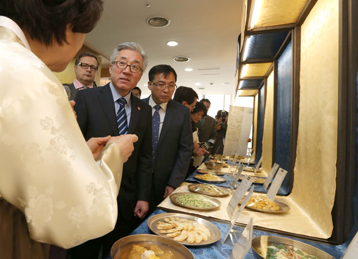 Attendees at the food tasting at Korea House in Seoul on March 25 listen to an explanation about the '<i>Eumsik Dimibang</i>,' the first cookbook written in Korean.