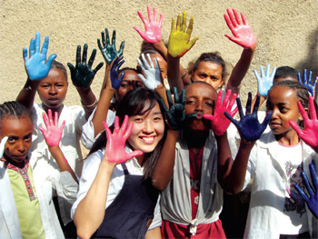 KOICA's Volunteers Overseas: A woman who volunteered to work as an art teacher shares a joyous moment with her students during a hand printing class.