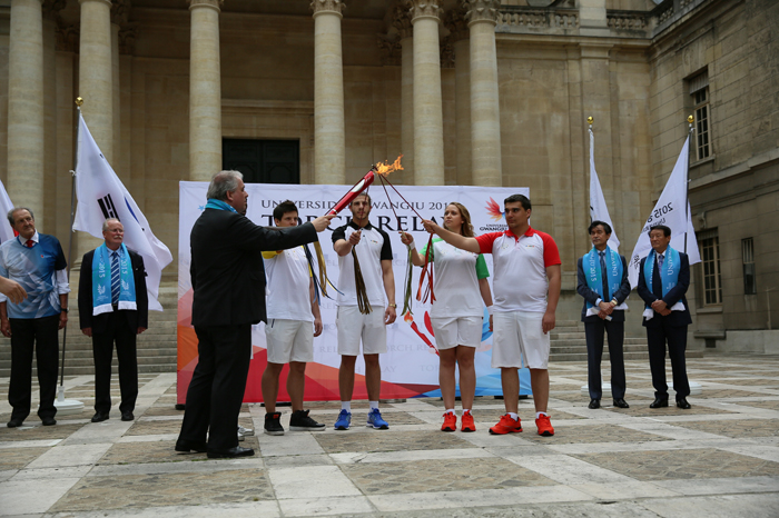 Barthélémy Jobert, president of Paris-Sorbonne University (bottom, left) lights the Gwangju Universiade torch with flames held by students representing five continents. 