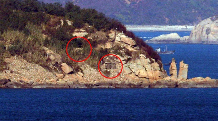 South and North Korea will stop all hostile military acts against each other on land, sea and air under their Sept. 19 military agreement. On Nov. 1, North Korea’s coastline artillery is seen covered and closed on the Yellow Sea border island of Jangjaedo in the North. The photo was taken from the Manghyang lookout of Yeonpyeongdo Island in the South. (Yonhap News)