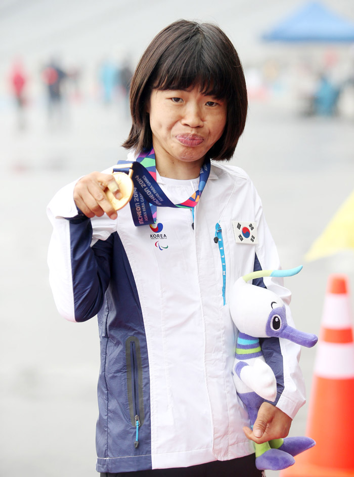 Jeon Min-jae holds up her gold medal after winning the women's 100 meter T36 race at the Asian Para Games in Incheon on October 20. 