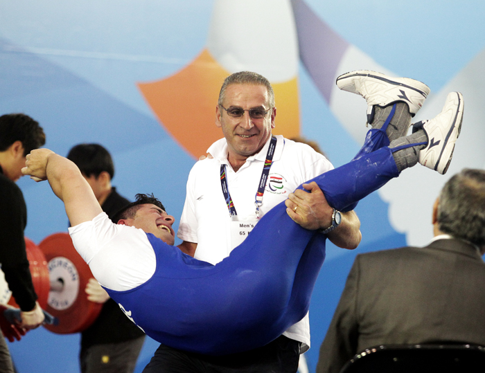  Issa Shadi from Syria is overwhelmed after winning a bronze medal in weightlifting in the men's 65 kilograms class at the Moonlight Festival Garden Powerlifting Venue on October 21. 