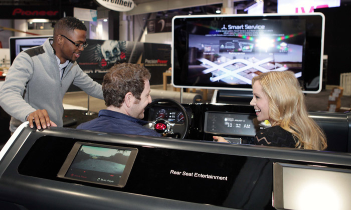 Visitors try out the new UVO system at the Kia Motors booth at CES 2014. 