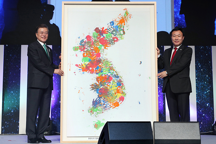 President Moon Jae-in (left) receives a map of the Korean Peninsula painted by children from a Korean language school in Germany from Choi Young-keun, president of the Korean Community of Wiesbaden, during the opening ceremony for the 11th Korean Day and the 2017 World Korean Community Leaders' Convention, at Lotte Hotel World in Songpa-gu District, Seoul, on Sept. 27. (Cheong Wa Dae)