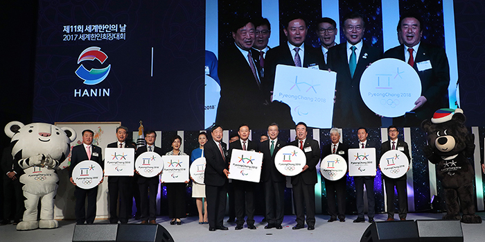 President Moon Jae-in poses for a photo with leaders of overseas Korean communities after giving them PyeongChang 2018 Olympic and Paralympic Winter Games badges, during the opening ceremony for the 11th Korean Day and the 2017 World Korean Community Leaders' Convention, at Lotte Hotel World in Songpa-gu District, Seoul, on Sept. 27.