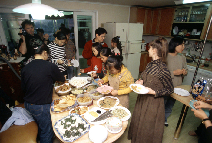 Foreign lodgers dine with their host family while staying at a Korean family house (photo: Yonhap News). 