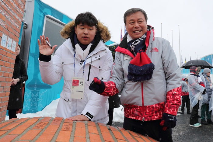 Cross-country skier Park DoHyeon (left) and Minister of Culture, Sports and Tourism Do Jonghwan pose for a photo after signing the mural on March 8.
