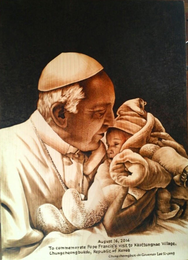  A pyrograph is given to Pope Francis by the government of Chungcheongbuk-do when he visited the Kkotdongnae, a welfare facility for the disabled. The pyrograph has an image of the pope holding a baby. (photo: Chungcheongbuk-do) 