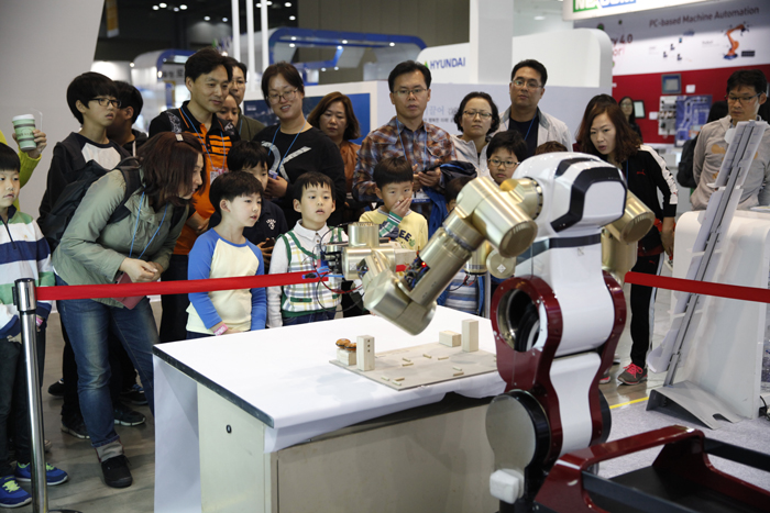 '2014 로보월드'에서는 방문객들이 로봇이 작동하는 모습을 지켜보고 있다. 