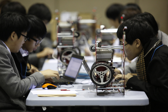 Adolescents take part in the International Robot Contest during the 2014 Robot World. 