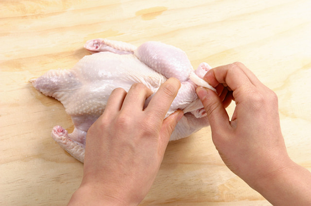 Stuff the chicken stomach with glutinous rice, ginseng, garlic and jujubes. Cross the chicken legs and tie it closed to prevent it from leaking.