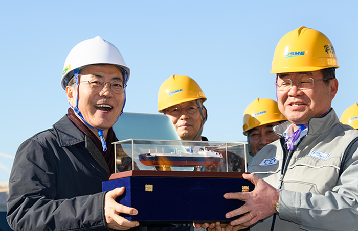 President Moon Jae-in (left) smiles as he receives a model of the icebreaker LNG carrier tanker 'Vladimir Rusanov' from Daewoo Shipbuilding and Marine Engineering CEO Jung Sung-leep, at Daewoo's Okpo Shipyard in Geoje, Gyeongsangnam-do Province, on Jan. 3.
