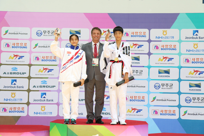 Hoss Rafaty (middle), secretary general of the World Taekwondo Federation, stands on the podium with the men's and women's MVPs during the closing ceremony at the second World Taekwondo Federation's World Cadet Taekwondo Championships in Muju, Jeollabuk-do. Korea's Lee Gi-yeong (right), who won the male -49kg division, and Thailand's Ploylapus Chaiprasit (left), who topped the -41kg weight division, were named as the MVPs for the tournament.