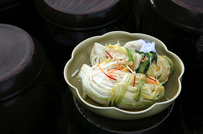 Place a cotton cloth containing the shredded ginger, garlic, fragrant vegetables and chili pepper into a large jar of dried yellow pollack stock. Put the stuffed cabbage in the jar filled with kimchi stock and leave it for 1 or 2 days at room temperature. Dried yellow pollack makes the stock tastier. Fruit can be also added.