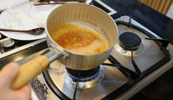 Put the white sugar into a small sauce pan over medium heat. As it melts, it becomes brown. Add the oil, starch and water. Boil it together until it's caramelized. This makes it not too sweet and allows the taste of the individual ingredients to shine through. This technique can be used also in other types of Korean cuisine, such as when making stir-fried <i>japchae</i> noodles, as well as when making <i>yaksik</i>. 