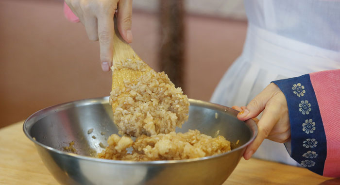 To the steamed rice, add all the ingredients, from the soy sauce through to the white sugar, starting with the darker-colored ingredients. Use both white sugar and brown sugar in order to preserve the fragrance and the taste. Add the chestnuts and pine nuts afterward, otherwise the nuts become soft or crushed. You can also add dried raisins, if you want. 