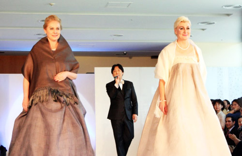 The audience members at the June 2012 Baek Hyun Ju Hanbok fashion show applaud in appreciation as the wives of foreign ambassadors appear on the catwalk for the show's finale (photo: Yonhap News).