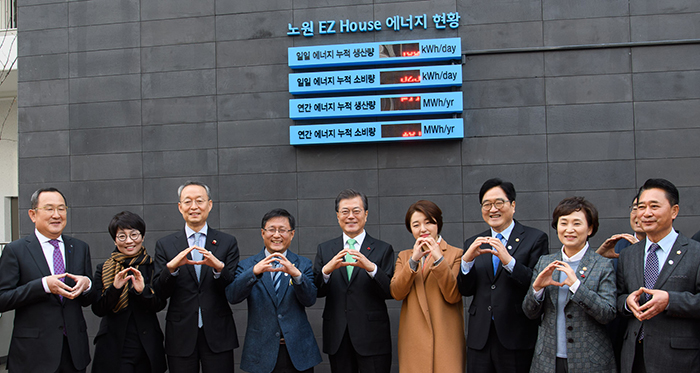 President Moon Jae-in and government officials pose for a photo in front of the zero-energy apartment complex, the Nowon Energy Zero Houses, in Nowon-gu District, Seoul, on Dec. 7.
