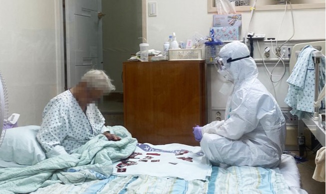 Viral photo shows nurse playing cards with elderly COVID-19 patient