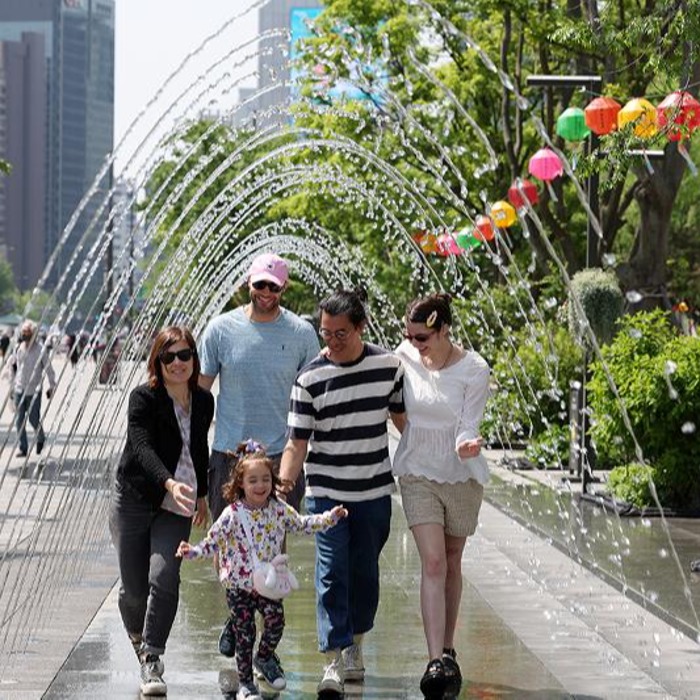 French family walks through cool fountain tunnel