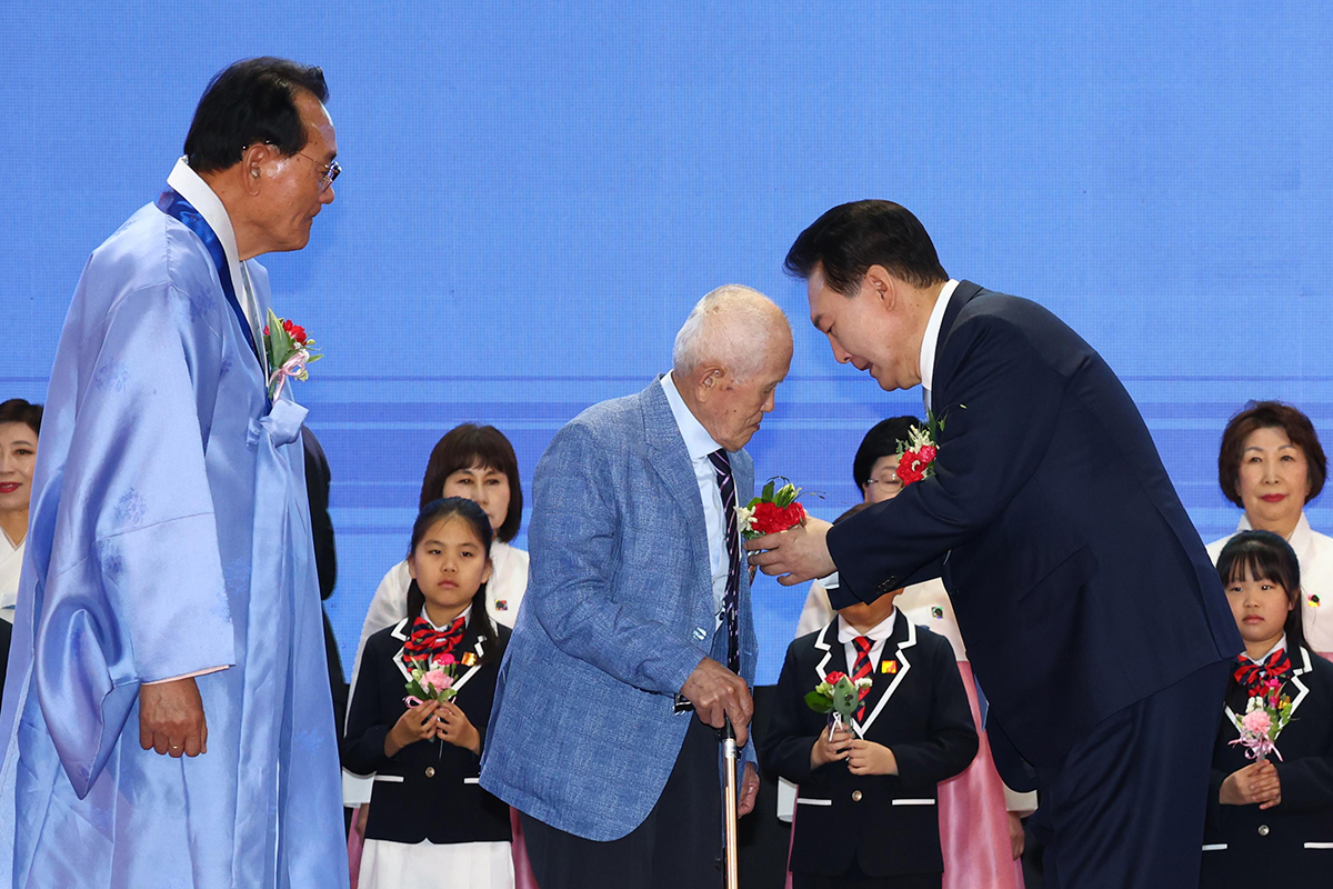 President Yoon on May 3 pins a carnation on a senior citizen at a Parents' Day ceremony held at Jangchung Arena in Seoul's Jung-gu District. 
