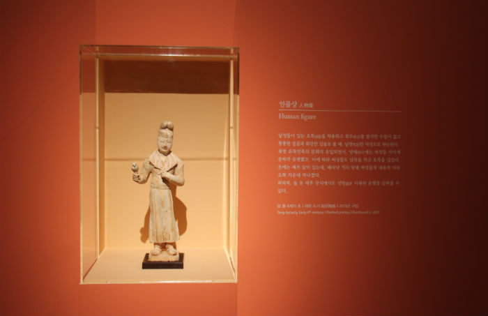 This human-like figurine is believed to have been manufactured in the early 8th century in China during the Tang Dynasty. The figurine is believed to be female, though she is wearing a man's garments and headgear. Archeologists believe it represents a woman taking part in a traditionally