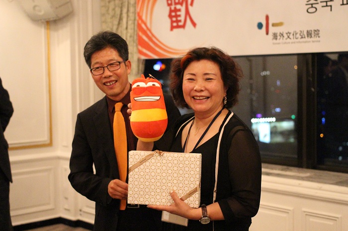 (Top) Wu Changsheng, head of the Chinese delegation, presents a bottle of Chinese traditional alcohol as a gift to Director Won Yong-gi of KOCIS. (Bottom) Director Won gives a gift to Zhuang Yuanyuan, senior reporter at CCTV. (photos: Wi Tack-whan) 