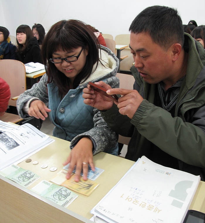 Students at the King Sejong Institute in Weihai, China, learn the denomination of Korean banknotes. (photo courtesy of the King Sejong Institute Foundation)