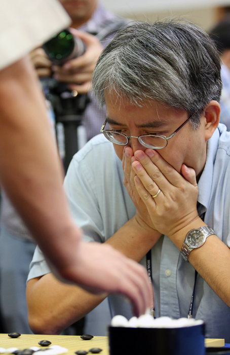 Tao Li, a participant from the U.S., ponders over what to do next in a game against Lee Chang-ho.