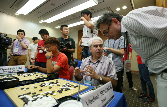 Vladimir Rovenski, a participant hailing from Israel, explains to his friend the current state of play in a game against Lee Chang-ho.