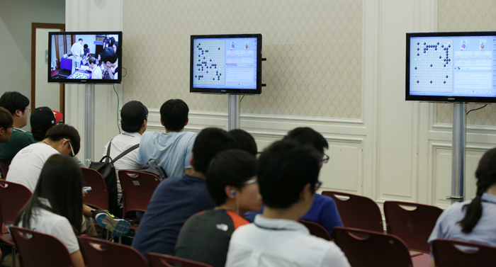 Those not able to get through to where the competition takes place watch games through screens installed outside the hall.