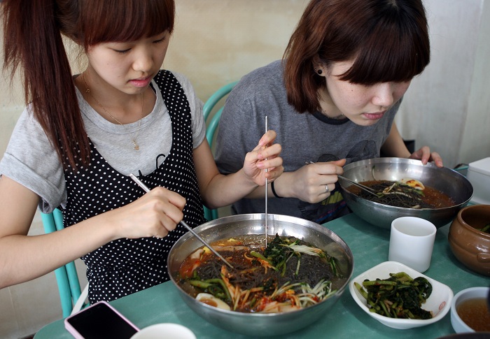 Cold noodle restaurants in Hwapyeong-dong provide abundant amounts of food at affordable prices. (photo: Yonhap News) 