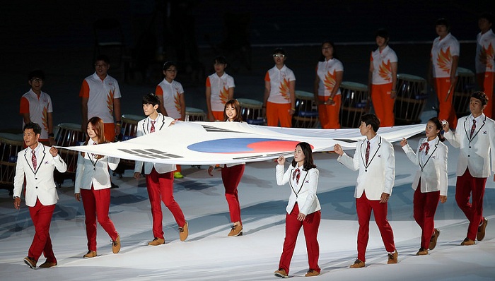 Eight Korean medalists enter the stadium holding the national flag to open the second part of the closing ceremony.