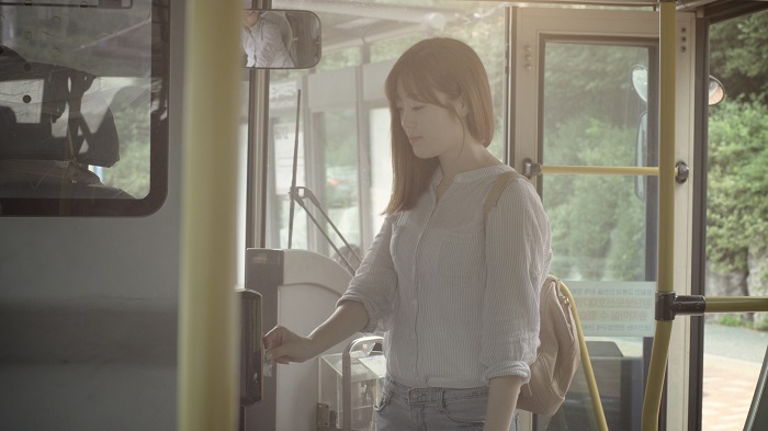 A passenger pays her fare with a transportation card.