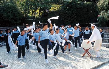 Elementary school students practice a mask dance.