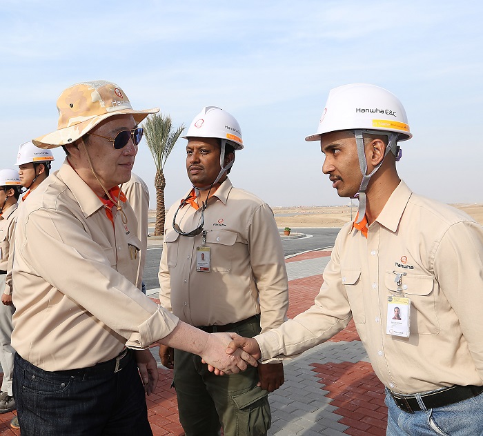 Kim Seung-youn (left), chairman of the Hanwha Group, encourages the workers building the new city in Bismayah.