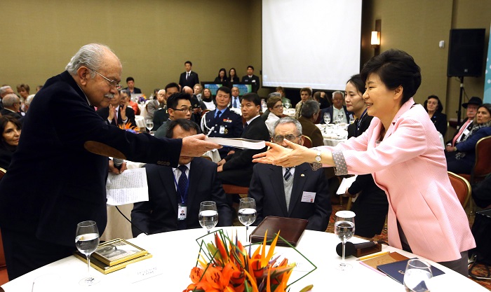 (Top) Francisco M. Caicedo (second from left), a retired army colonel, receives an autograph from the then Korean president, Park Chung-hee in 1975. (Bottom) Some 40 years later, Francisco Caicedo meets with President Park on April 18 to hand her an autobiography about his experiences during the war.