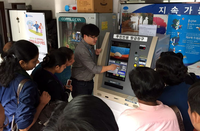 Public officers from Laos, Myanmar and Sri Lanka learn how to use an unmanned kiosk to issue resident registration documents. They were visiting a neighborhood government office in Gimpo, Gyeonggi-do Province, on Oct. 27.