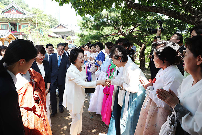 First lady Kim Jung-sook is greeted by the faithful while visiting Bongeunsa Temple in Gangnam-gu District, Seoul, on July 25.