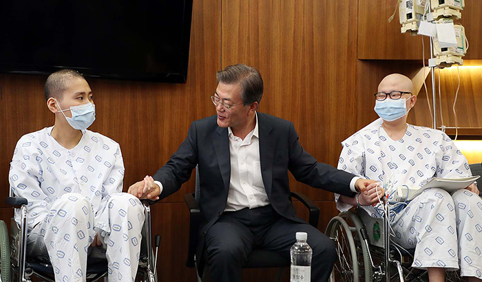 서울 서초구의 성모병원을 찾은 문재인 대통령(가운데)이 9일 환자들을 격려하고 있다.