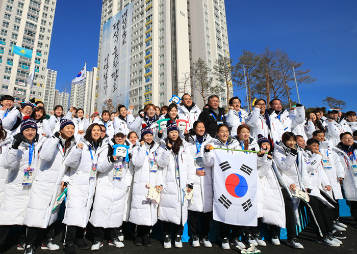 South Korean athletes pose with the Taegeukgi national flag after a welcoming ceremony at the Gangneung Olympic Village on Feb. 7. (Yonhap News)