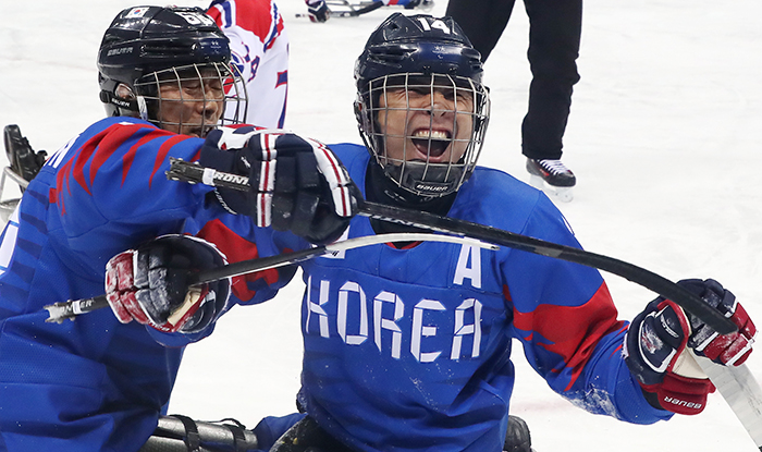 Jung Seung Hwan (second from left) and Han Minsu, the captain of the Korean para ice hockey team, celebrate after winning their preliminary match against the Czech Republic 3-2 at the Gangneung Ice Hockey Center on March 11. Jung scored two goals and was names as the MVP for the game. (Yonhap News)