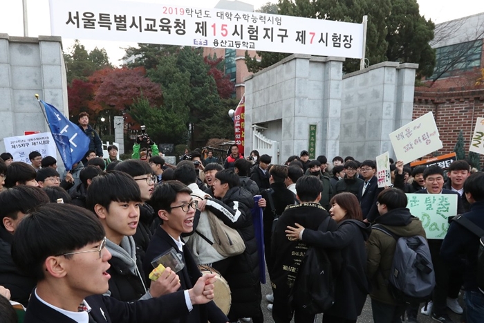 Senior high school students enter Yongsan High School in Yongsan-gu District, Seoul, a CSAT test venue, on the morning of Nov. 15 while receiving cheers and support from younger students and teachers. (Jeon So-hyang, Ministry of Culture, Sports and Tourism)