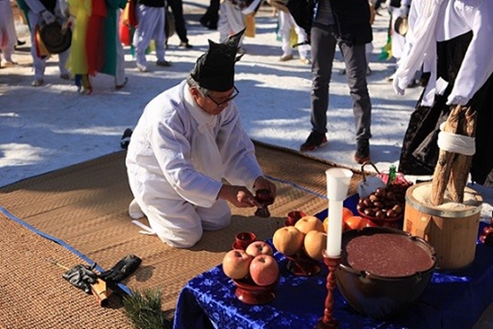 The National Folk Museum of Korea in a 2014 event reenacts dongji gosa (동지고사, 冬至告祀), a rite that offers patjuk (팥죽), or red bean porridge, to a family shrine at the museum’s outdoor showroom. (National Folk Museum of Korea)