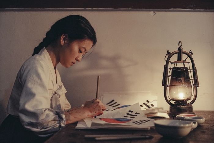 A scene from the film "A Resistance" shows Yu Gwan-sun drawing the Taegeukgi (Korean national flag) to participate in the independence movement.