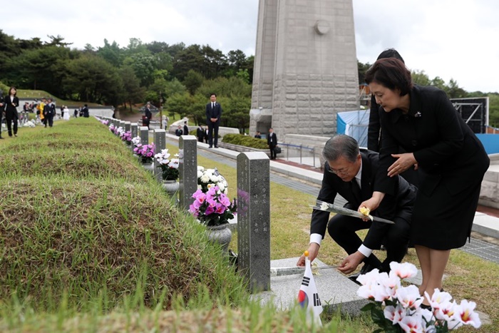 President Moon Jae-in and first lady Kim Jung-sook on May 18 lay flowers at the May 18 National Cemetery in Gwangju. (Cheong Wa Dae)